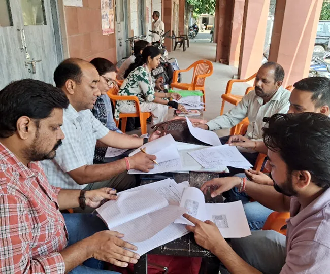 तहसील स्थित पोलिंग बूथ पर मतदाता सूचियों को देखते बीएलओ। जागरण